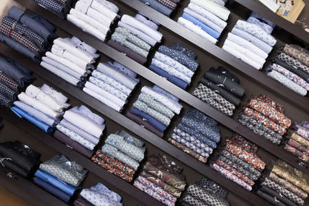 Men shirts displayed on shelves in shopの写真素材