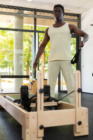 Man doing exercises on pilates reformerの写真素材