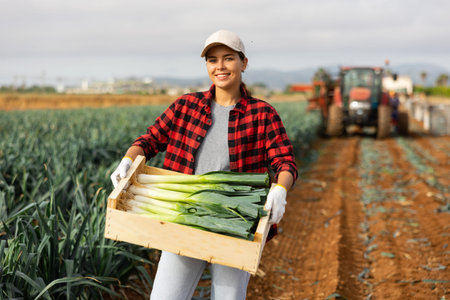 Woman posing with leek crop on field
