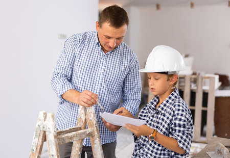 Father and son talking about space planning in new apartmentの写真素材