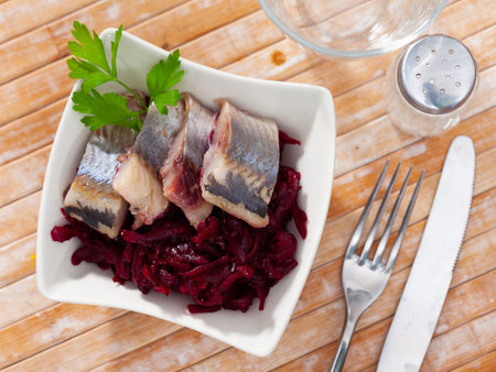 Slightly salted herring slices with grated beets and greens
