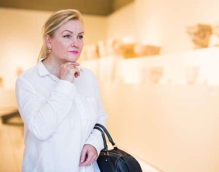 Portrait of senior woman visiting exposition at museumの写真素材
