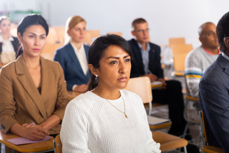 Focused Latina listening to speaker at business conference