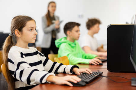 Young girl using computer during lessonの写真素材
