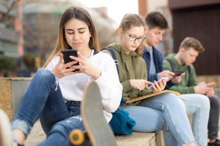 Teenagers are playing on smartphone on street