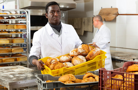 African baker carrying box with baked bread
