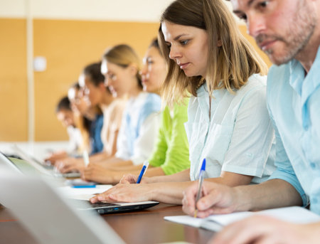 Woman university student writing in classroom