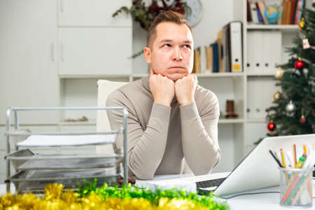 Portrait of tired man bookkeeper sitting at tableの写真素材