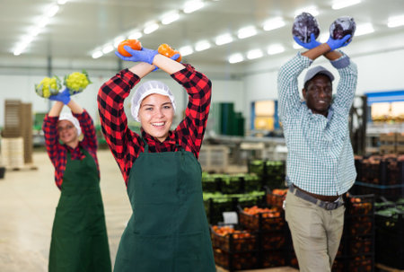 Vegetable warehouse workers preforming dance in workplaceの写真素材