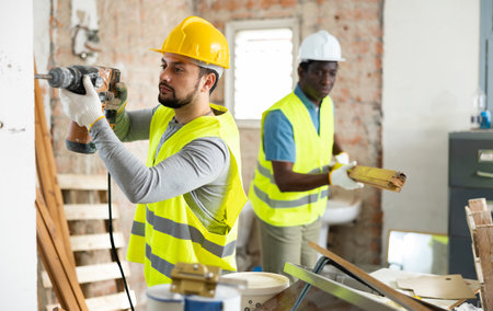 Two builders working on indoor construction siteの写真素材