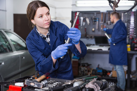 Female master is choosing instruments in workshopの写真素材