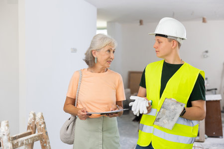 Woman talking with teenager on construction siteの写真素材