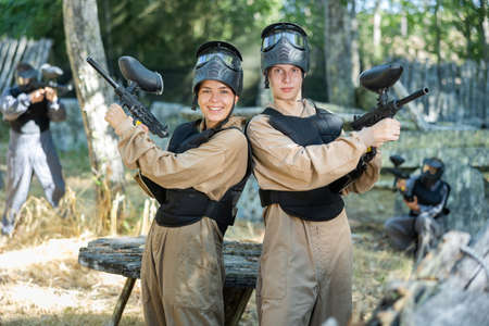 Cheerful boy and girl paintball players holding guns and posingの写真素材