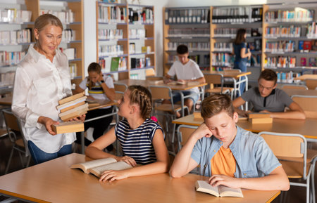 Happy teenage schoolers reading and writingの写真素材