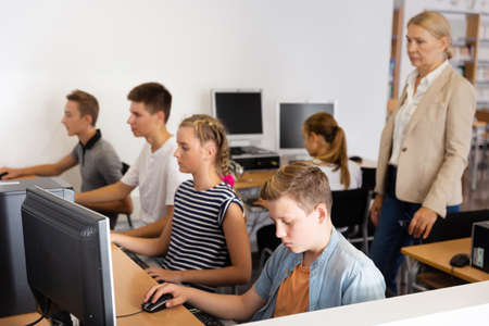 Students working with computers in classroomの写真素材