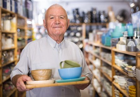 Mature man choosing new dishes at storeの写真素材