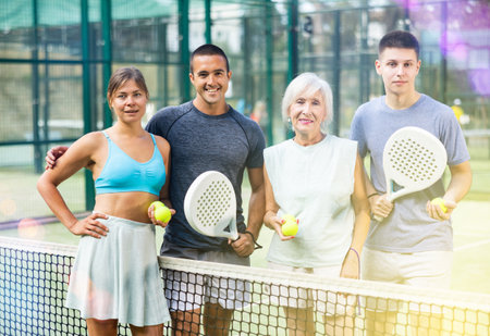 Portrait of four happy padel players on tennis court outdoorの写真素材