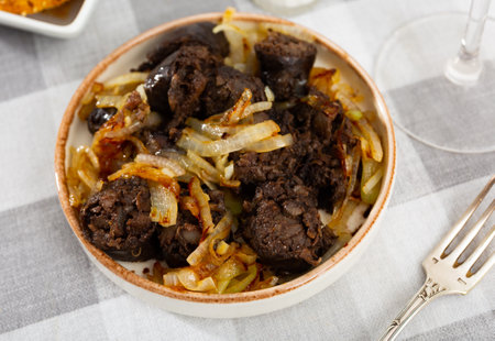 Morcilla con cebolla - fried blood sausage with onion on tableの写真素材