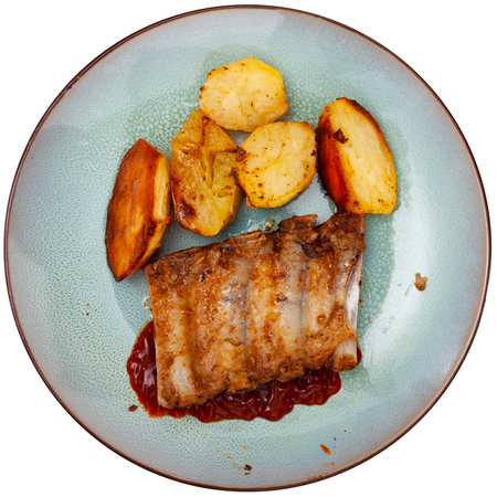 Baked under sauce pork ribs at plate with potatoesの写真素材