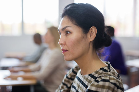 Focused japanese woman listening lecture at adult education class