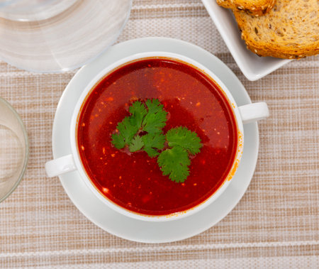 Beet soup with veal meat garnished with fresh parsley