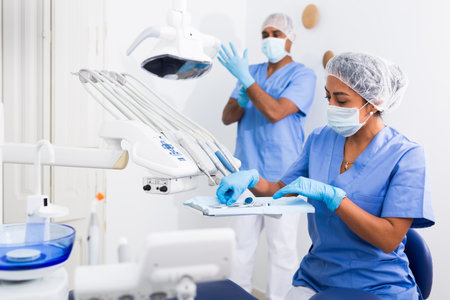 Female stomatologist preparing dental instruments for workの写真素材