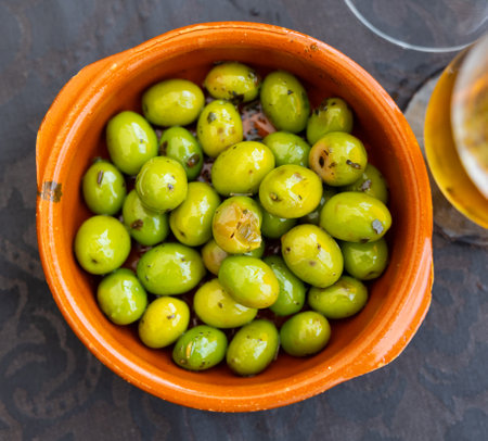 Trickle of pickled green olives on plateの写真素材