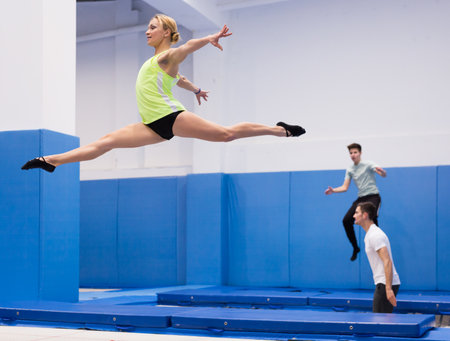 Woman jumping in trampoline centerの写真素材