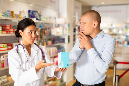 Man asks to help pharmacist choose medicine for toothacheの写真素材