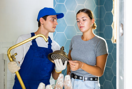 Woman asking for help from plumber in assembling new shower during renovationの写真素材