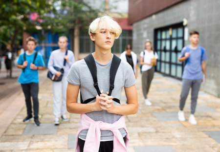 Teenager walking outside college building in autumn dayの写真素材