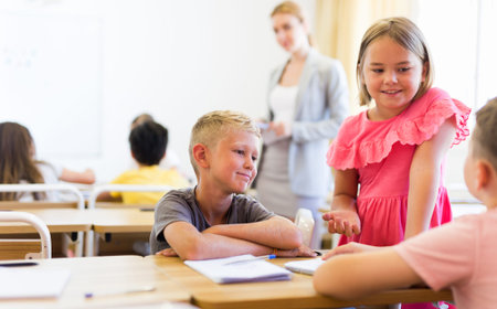 Preteen schoolchilds working in groups at lesson