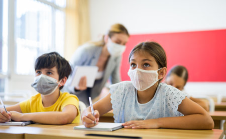 Teacher helping kids to complete exercisesの写真素材
