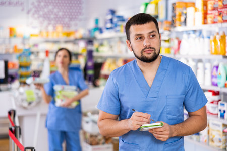 Portrait of male pharmacist working in drugstoreの写真素材