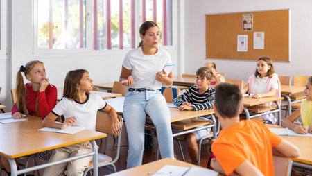 Teacher reading lecture to schoolkids in classroomの写真素材