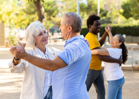 Elderly woman enjoying dance with partner in gardenの写真素材
