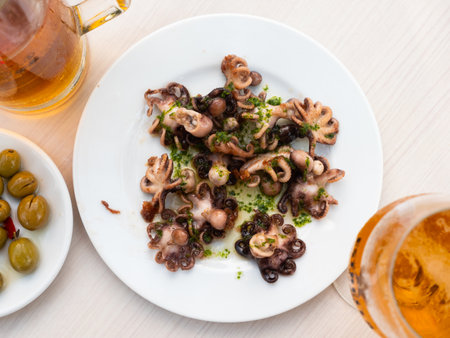 Fried octopus dish with herbs and sauce and beer closeupの写真素材