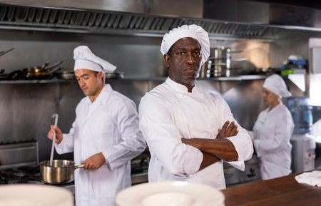 Man head chef posing in restaurant kitchenの写真素材