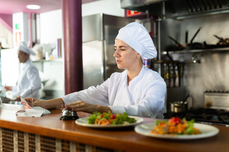 Chef checking orders and giving out meal