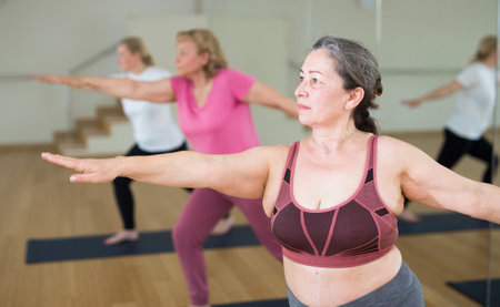 Active senior woman practicing yoga at groupの写真素材