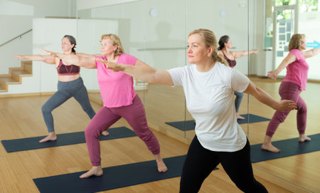 Women are doing warrior II poseの写真素材