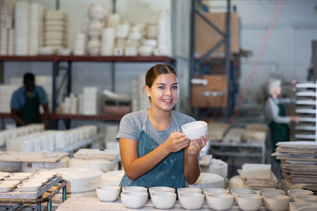 Female potter arrange pottery plate at factory ceramicの写真素材