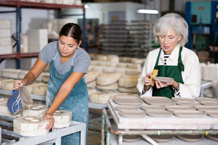Pouring slip mass into plaster molds at pottery factoryの写真素材