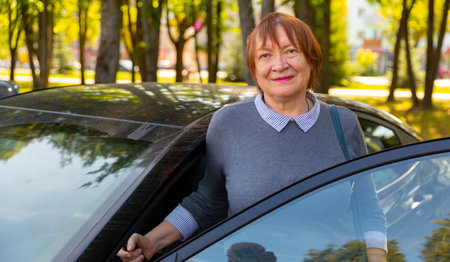 Portrait of positive mature woman, about to get into carの写真素材