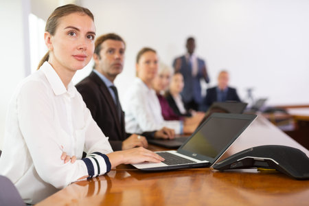Portrait of business woman using laptop at business meeting