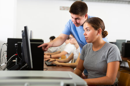 Teacher and teenage student studying in computer classの写真素材