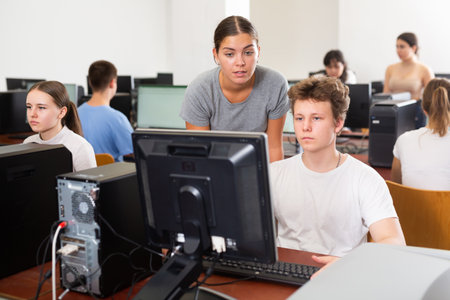 Schoolboy and teacher using PC in computer classの写真素材