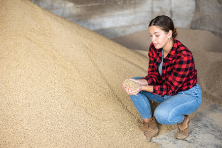 Young woman with calf feed in storehouseの写真素材