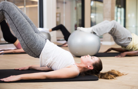 Girl exercising with pilates ball during group classの写真素材