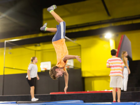Boy jumping on trampoline park in sport centerの写真素材